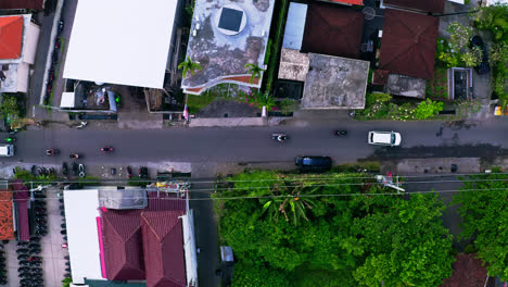 Car-and-scooter-traffic-on-street-in-residential-neighborhood,-Canggu