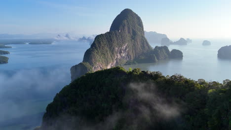 mist around the karst cliffs over phang nga bay in thailand. - aerial shot