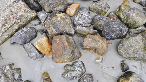 waves gently wash over rocks on the beach