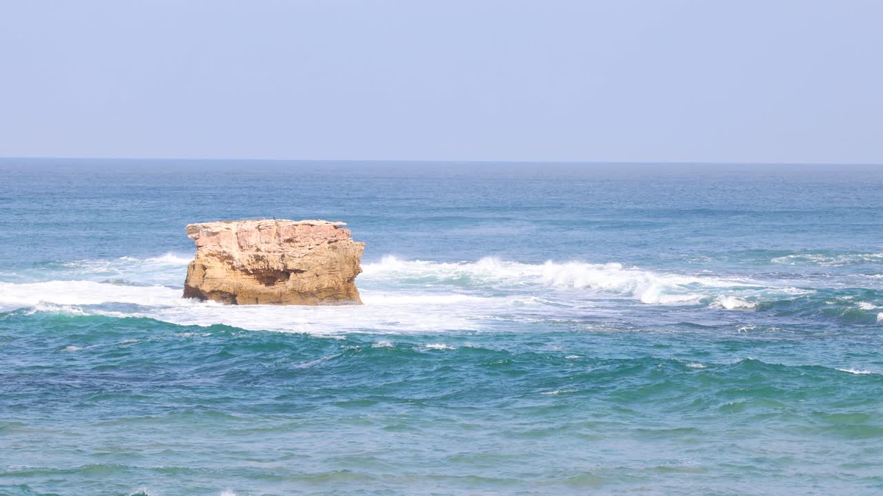 las olas del océano golpean una formación rocosa solitaria