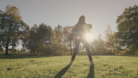 The-silhouette-of-a-happy-mom,-playing-with-her-two-year-old-son-in-the-park.-The-rays-of-the-setting-sun-illuminate-them