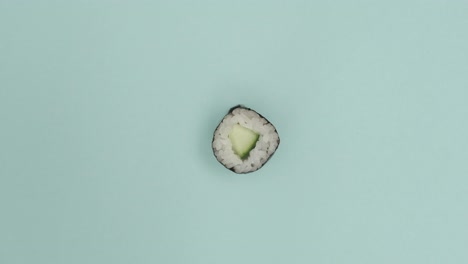 un rollo de sushi girando sobre un fondo azul