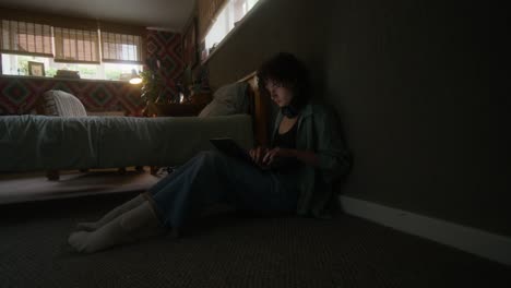 young woman working on laptop in bedroom