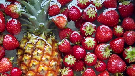 zoom in on fresh pineapple and strawberries floating in sink