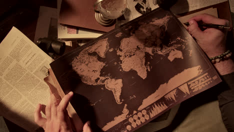 person studying a vintage world map