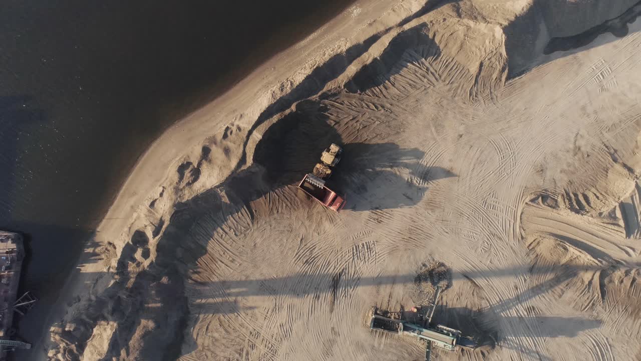 강변 근처 의 모래 파기 작업 의 공중 사진