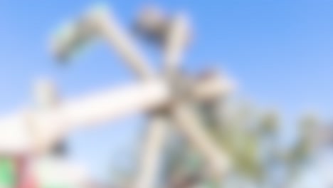 blurred carnival ride spins rapidly against a clear blue sky, creating a dynamic and energetic atmosphere