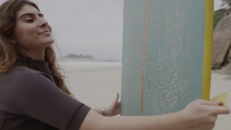 young woman on a beach with a surfboard