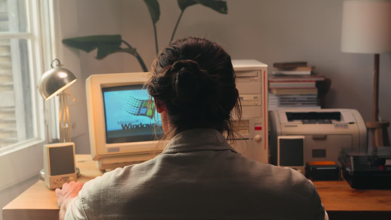 BARCELONA, SPAIN, 10 JUNE 2025. Man working and gaming on retro computer PC, IT engineer with vintage computer at home, using old fashion technology, close up of retro setup.