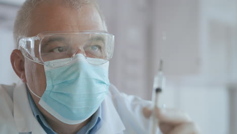 las manos del médico preparando una jeringa con antibiótico para el tratamiento intravenoso. una jeringa con un medicamento con una vacuna está en las manos de un médico el medicamento se exprime fuera de la jeringa cae. imágenes de alta calidad 4k