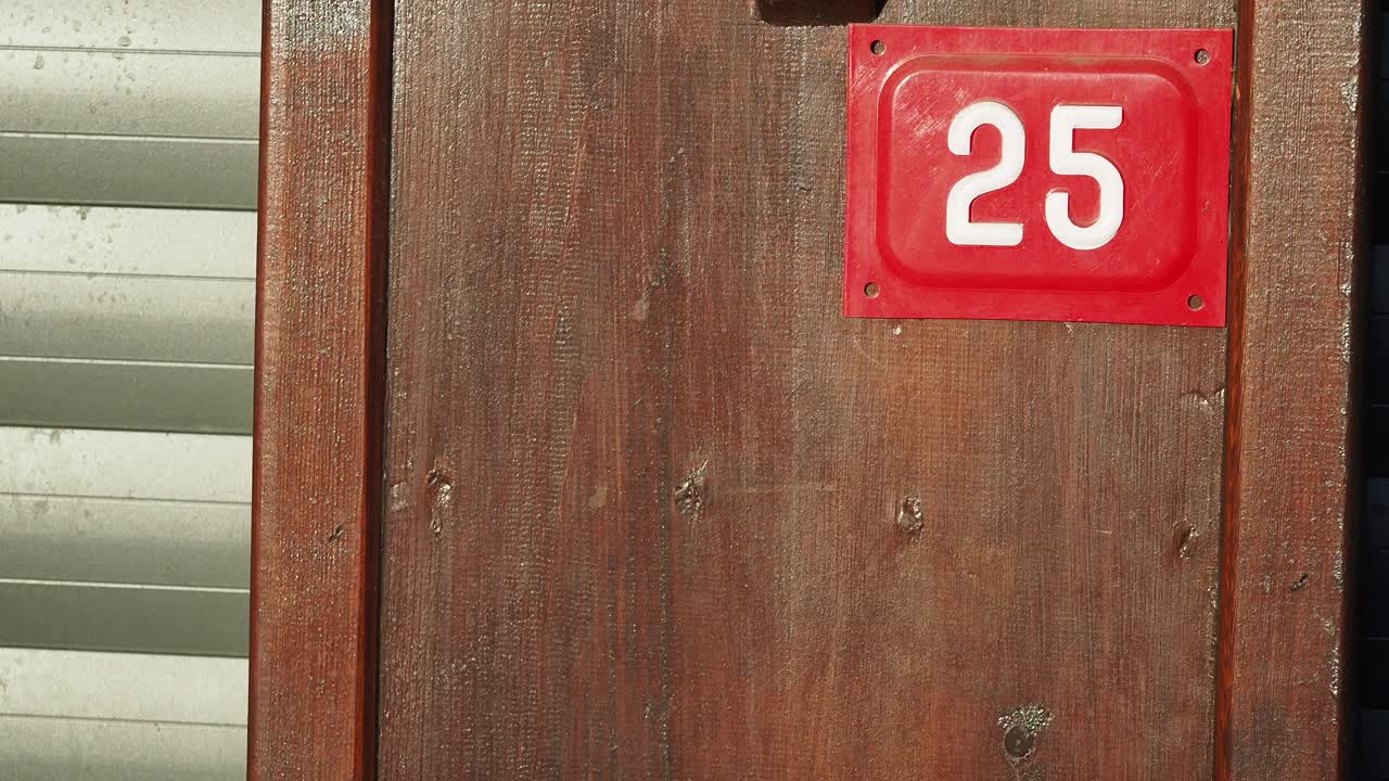 나무 문 위에 있는 집 번호 25