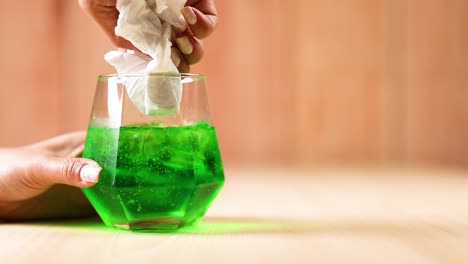 limpieza manual del vidrio con pañuelo y líquido verde