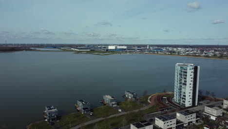 aerial view of a dutch cityscape with waterfront, industrial area, and residential buildings.