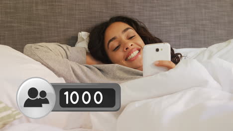 mujer acostada en la cama sonriendo mientras envía mensajes de texto en su teléfono 4k