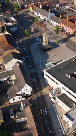 portrait top-down drone flight along hoddesdon high street with bus, shops, and car park