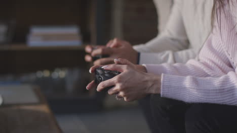 close up of couple relaxing on lounge sofa at home and playing computer game together