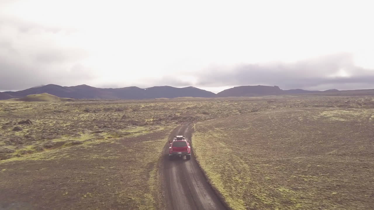 Red Jeep Driving Through Icelandic Lava Fields