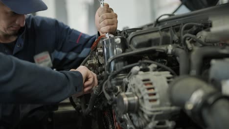 mechanic repairing car engine in auto workshop