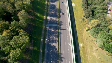 Toma-Aérea-De-Arriba-Hacia-Abajo-Del-Tráfico-En-Una-Carretera-Moderna-Construida-En-Una-Zona-Rural-De-Polonia-Cerca-De-Gdynia