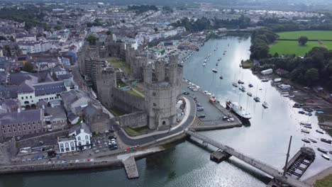 antiguo castillo de caernarfon puerto galés ciudad vista aérea medieval frente al mar punto de referencia rápido zoom out