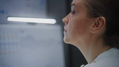 close up of serious female stock exchange broker monitoring real-time stocks, exchange market charts. unfocused computer with multi-monitor desktop. professional investment agent working in office.