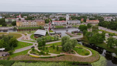 drone reveals latvian river island, scenic bridge and urban landscape in jelgava