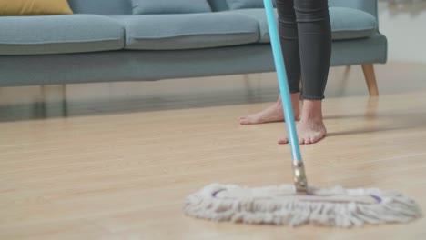 mujer limpiando un piso de madera
