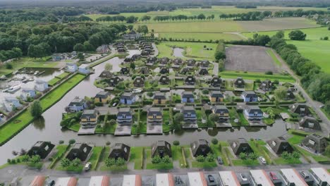 aerial flyover a small dutch holiday park during summer with different houses surrounded by water