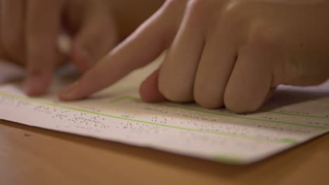 person learning to read braille lettering