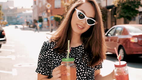 happy young woman drinking in the city