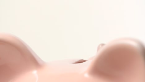 돼지 저금통에 1파운드 동전 넣기