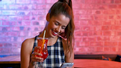 happy woman taking selfie on mobile phone while having cocktail