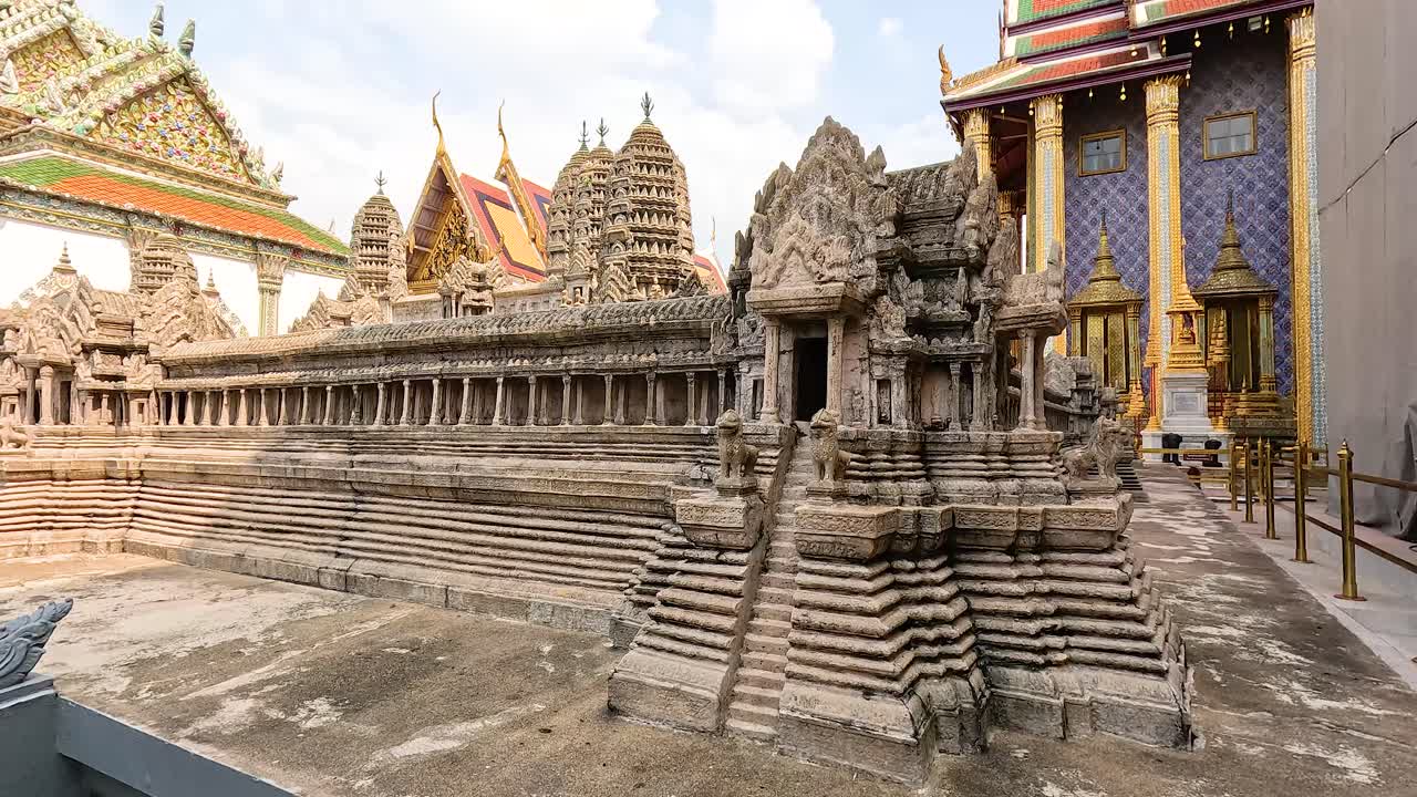 A detailed view of a miniature pagoda at Wat Phra Kaew, showcasing intricate architecture under bright daylight in Bangkok, Thailand