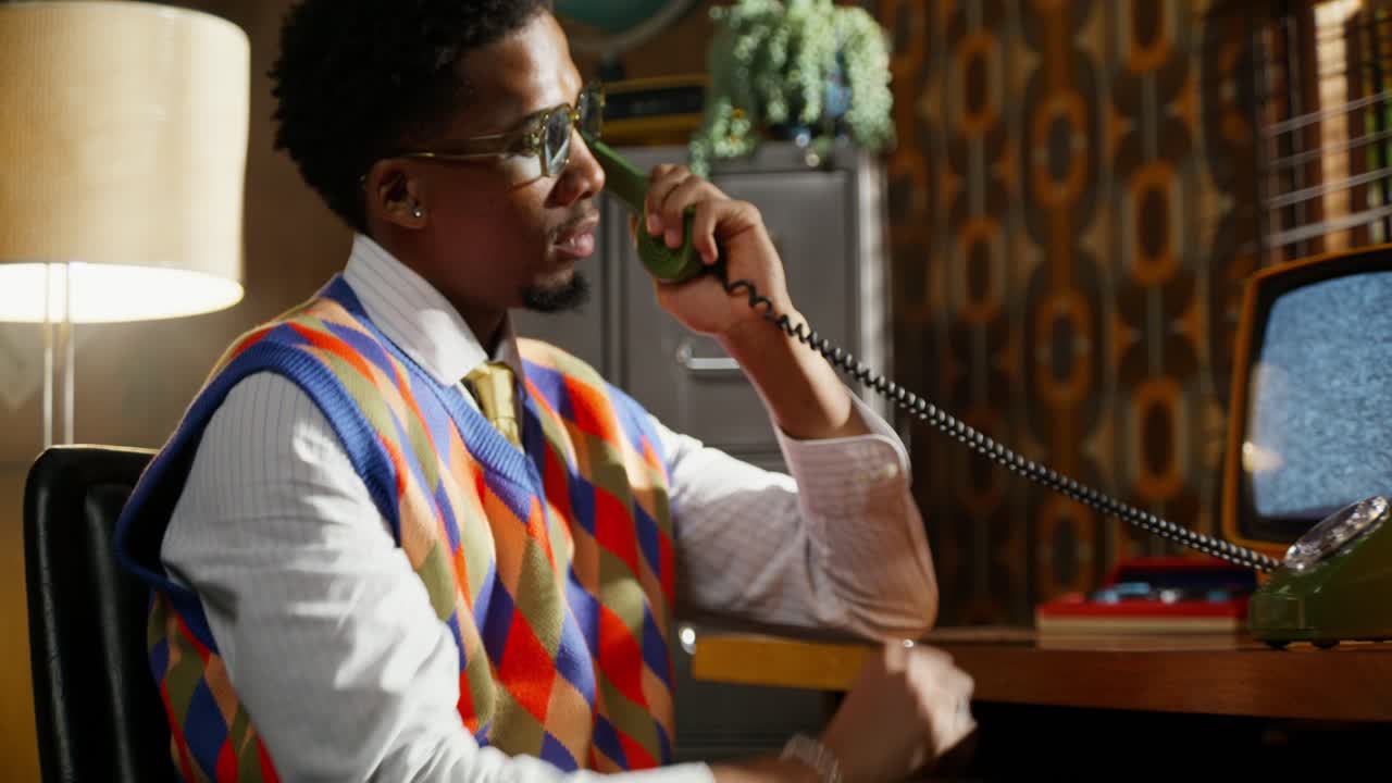 70 년대 또는 80 년대 사무실에서 레트로 전화로 이야기하는 남자