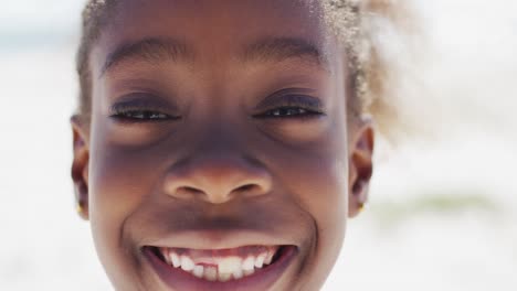 Glückliches-Afroamerikanisches-Mädchen,-Das-Am-Strand-In-Die-Kamera-Lächelt