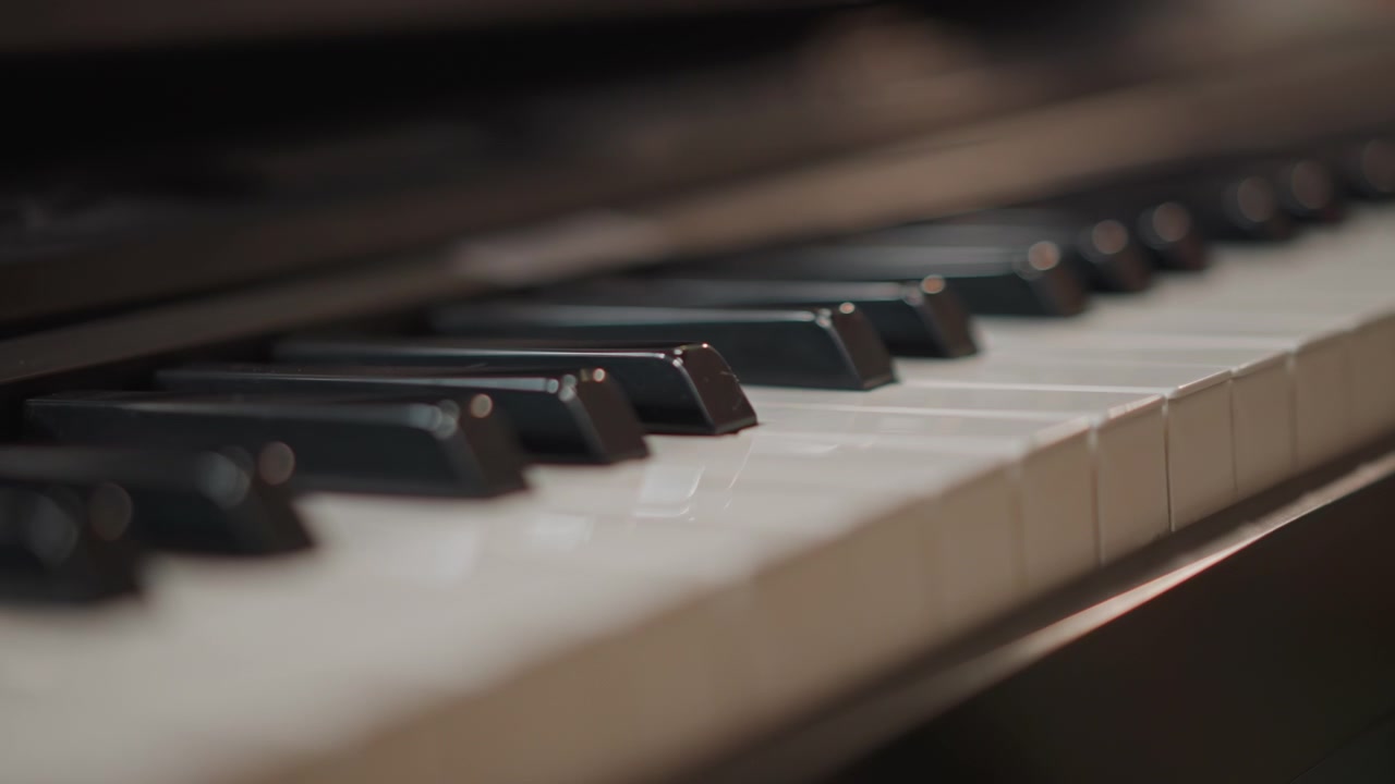 Closeup piano keys during practice session, warm studio lighting, shallow depth of field, ivory keys and black sharps, subtle bokeh, musician coaching vibe, gentle finger movement, intimate classical
