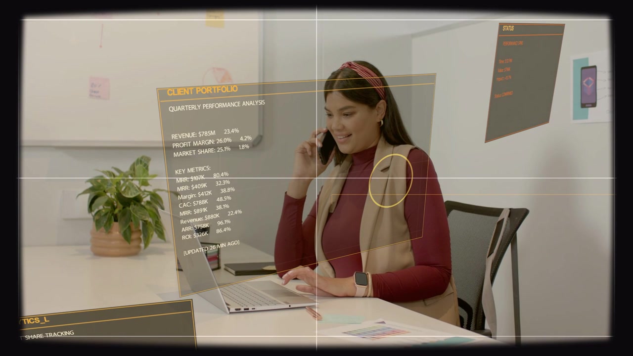 Mulher segurando o telefone e digitando no laptop, carregando uma UI de portfólio de clientes holográfica durante uma chamada de negócios.