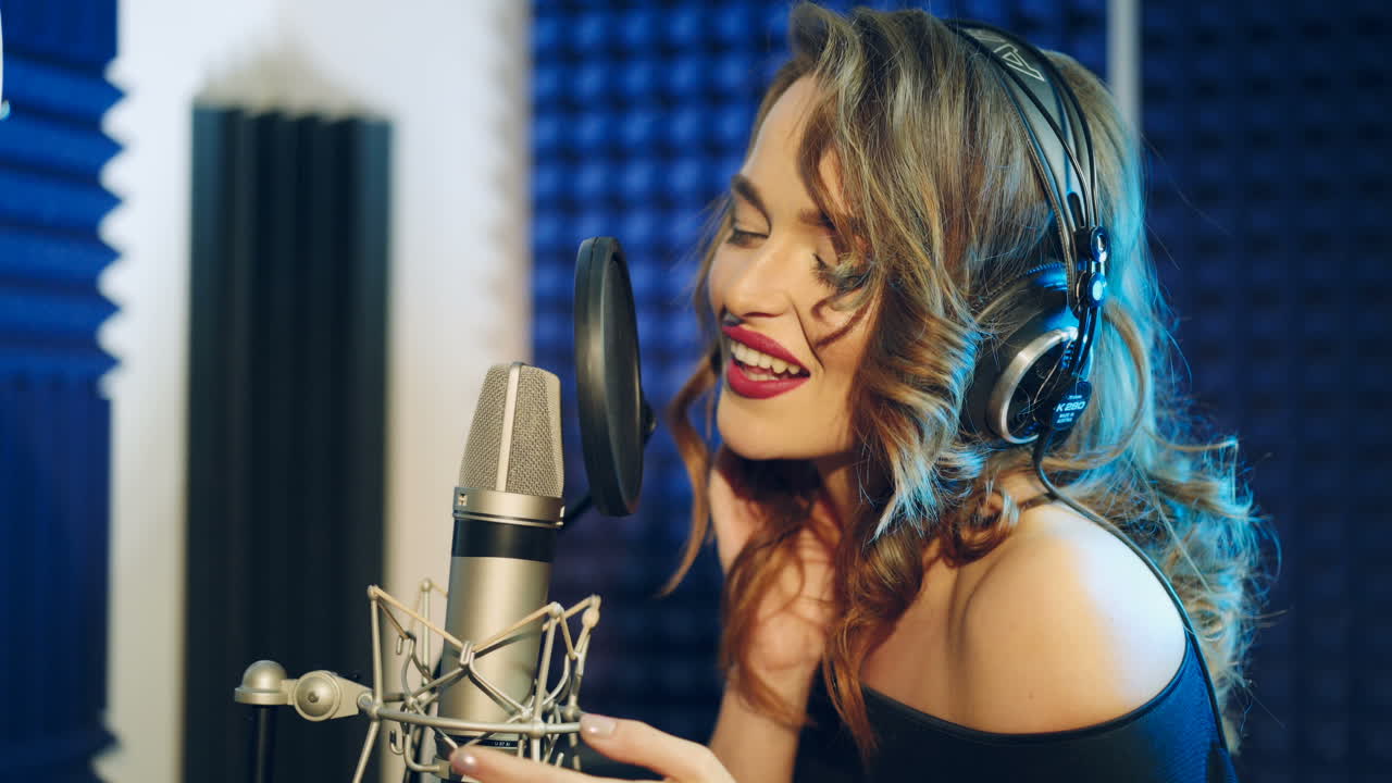 Vinnitsa, Ucraina - Maggio 2019: Giovane donna che registra una canzone in uno studio professionale. La ragazza canta nel microfono.