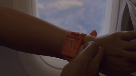 woman in the plane setting watch backward