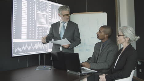 finance professional presenting stock market charts to his clients