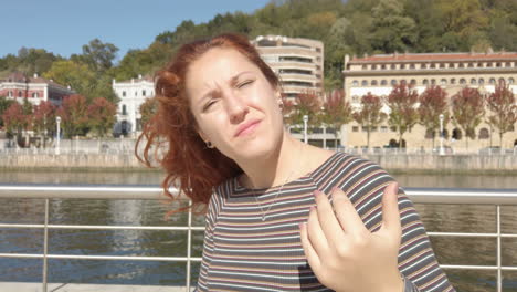 woman with red hair near river