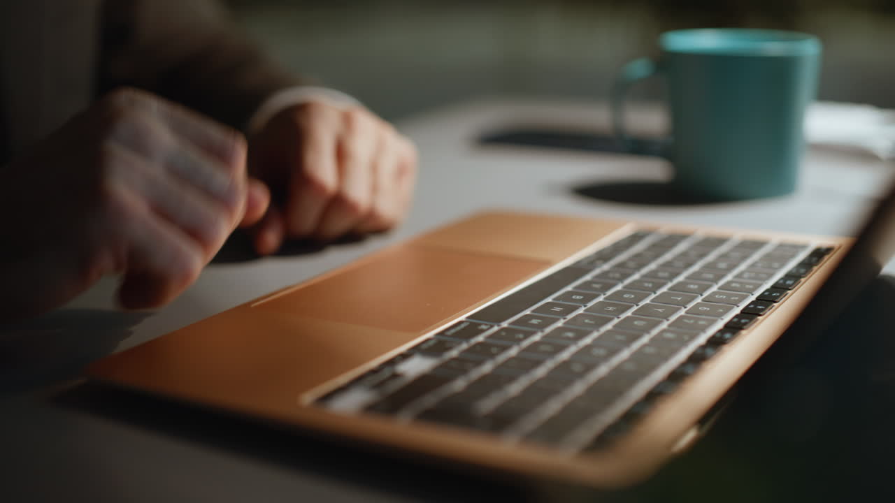 Man hand pressing touchpad laptop surfing internet at dark workplace closeup