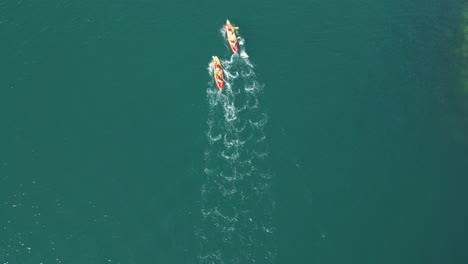 aerial shot of two people on their surfboard at the sea in aldan, spain