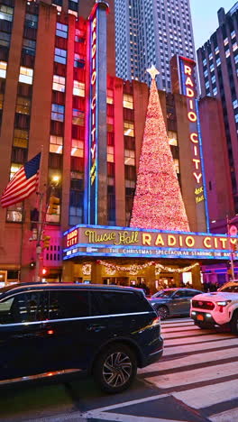 new york, usa, 20 december 2025: festive vibes in nyc. visitors explore the vibrant holiday decorations at radio city music hall, featuring a large christmas tree
