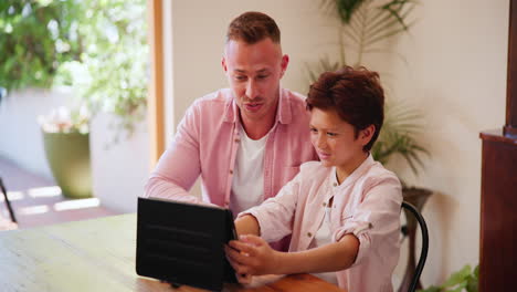 father, son and tablet watching talking