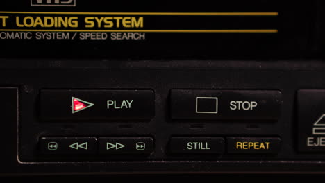inserting vhs video tape and pressing play button on vcr, close up