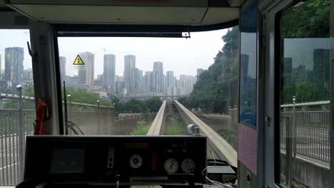 clip from inside a train-tram on rails arriving at a station in the city of chongqing in china