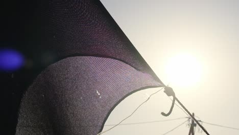 close-up of a large black military tent net stretched as the warm sun dazzles the lens