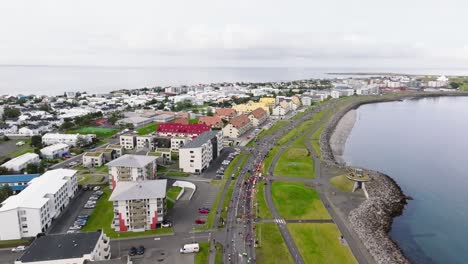 marathon runners on road in urban landscape of reykjavik, aerial