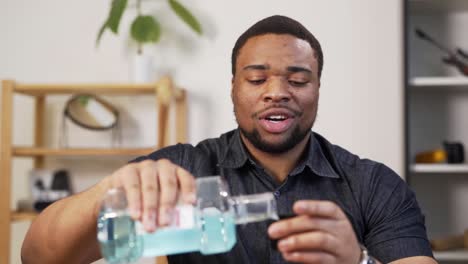 attractive charismatic black man rinses his mouth